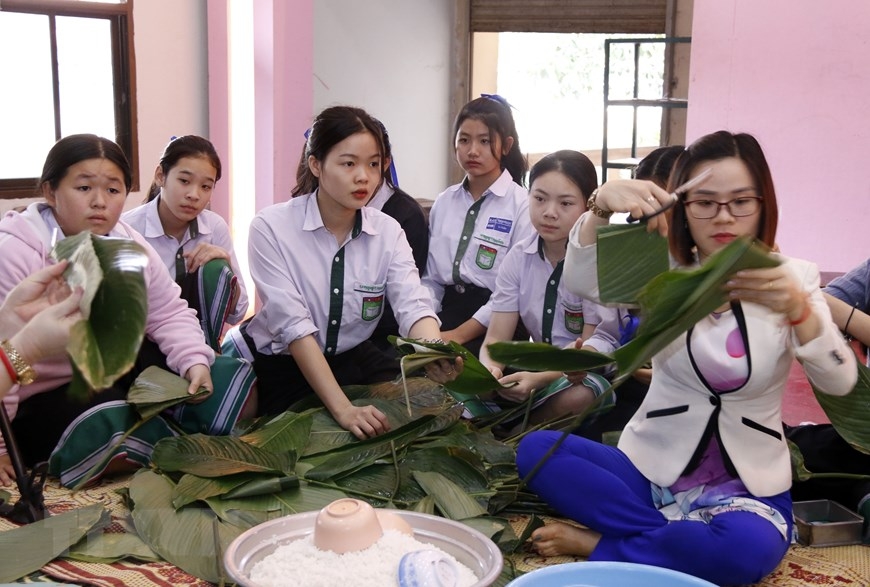 Nguyen du lao vietnamese bilingual school's students and teachers making “banh chung”