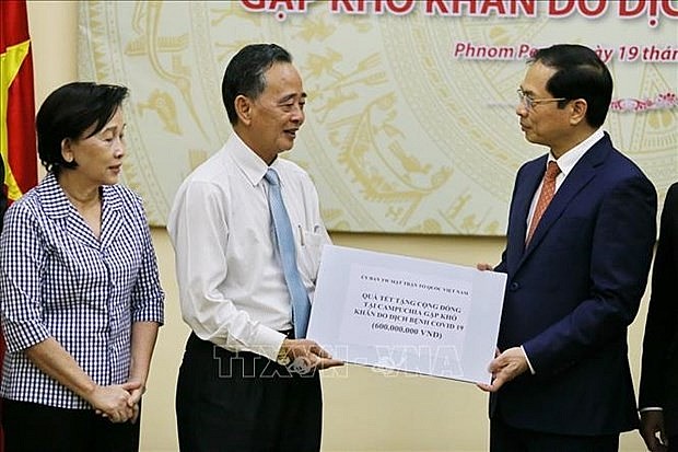President of the Khmer-Vietnam Association in Cambodia Sim Chy, on behalf of the Vietnamese expats there, receives pre-Tet gifts from Minister of Foreign Affairs Bui Thanh Son. (Photo: VNA)
