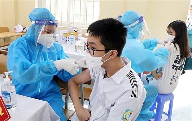 Students receive COVID-19 vaccine shots at a high school in the northern province of Phu Tho in late November 2021. (Photo:VNA)