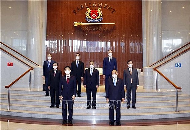 President Nguyen Xuan Phuc, Speaker of the Parliament of Singapore Tan Chuan-Jin and other delegates take a photo at the Parliament Building of Singapore 