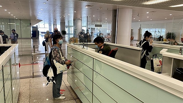 Foreign nationals from Singapore have their documents checked at passport control in Nội Bài International Airport, Hà Nội, on March 15, 2022. — VNA/