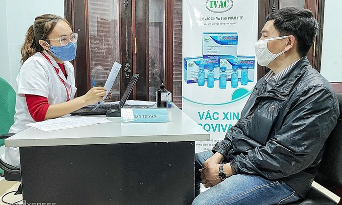 A researcher (L) informs a volunteer about the Covivac vaccine trials at the Hanoi Medical University. Photo by VnExpress