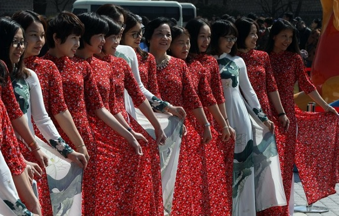 A group of Vietnamese tourists dressed in indigenous “ao dai” gowns poses for a photo in front of the presidential office in Seoul on April 3, 2019. (Yonhap)