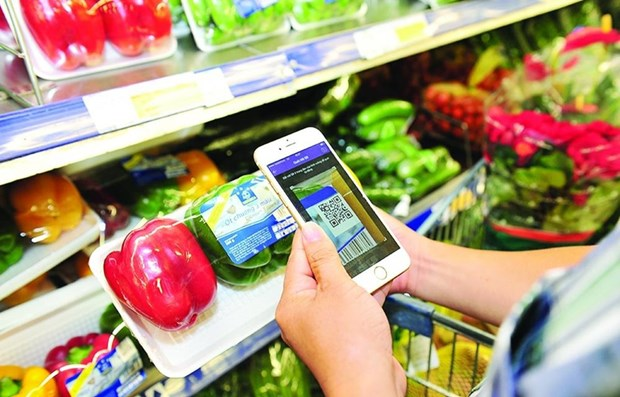 A customer uses smart phone to scan code on a product (Photo: VNA)