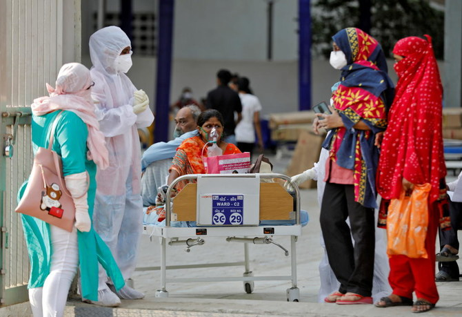 Patients sit on bed waiting to be moved to a hospital, amidst the spread of the coronavirus disease (COVID-19) in Ahmedabad, India, April 14, 2021. (Reuters)