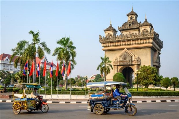 Vehicles pass through Patuxay Monument in Vientiane (Illustrative photo: AFP/VNA)