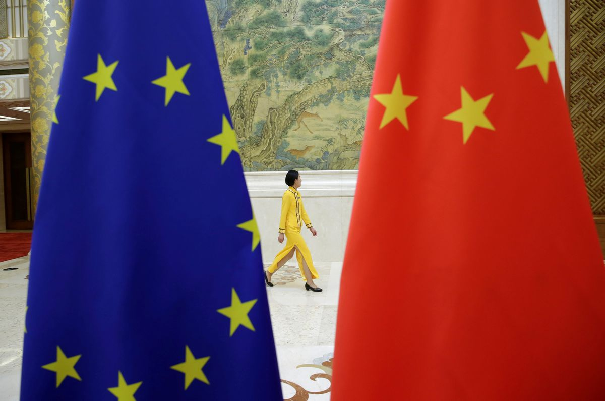 An attendant walks past EU and China flags ahead of the EU-China High-level Economic Dialogue at Diaoyutai State Guesthouse in Beijing, China June 25, 2018. Photo by Reuters/Jason Lee.