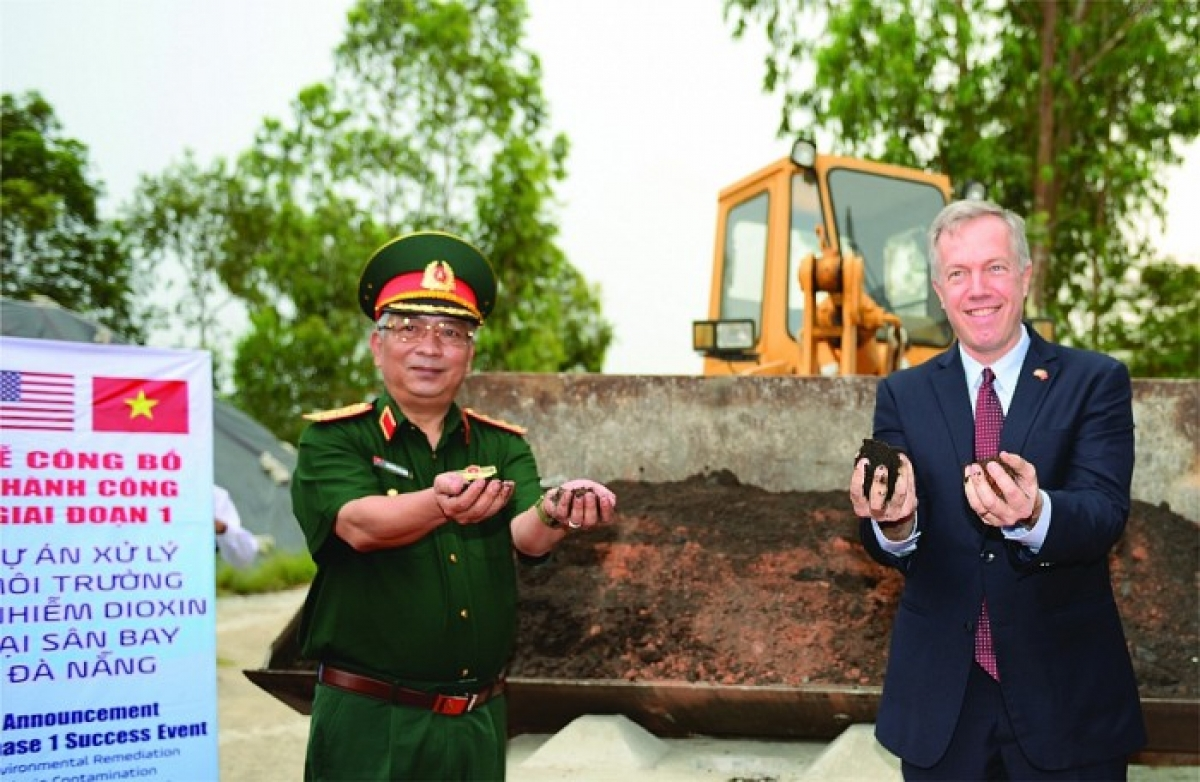 Deputy Minister of Defense Nguyen Chi Vinh and former US Ambassador to Vietnam Ted Osius holding a handful of soil that has been completely decontaminated at Da Nang Airport. (Photo: Ministry of Foreign Affairs)