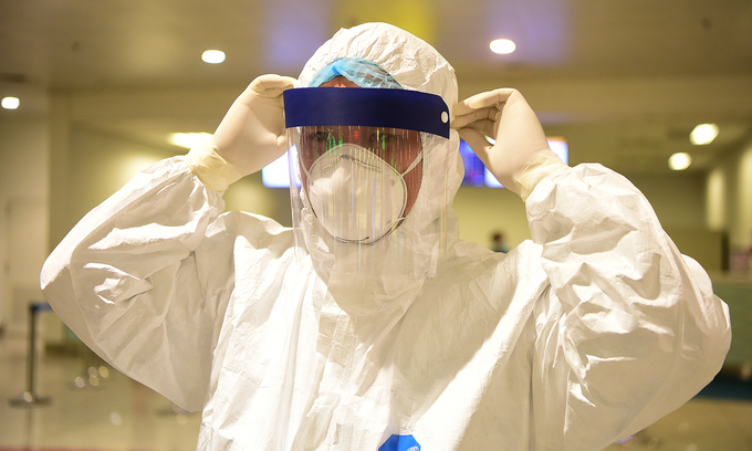 A medical worker is equipped with a medical mask, face shield and protective suit at Hanoi's Noi Bai Airport, March 18, 2020. Photo by VnExpress/Giang Huy.