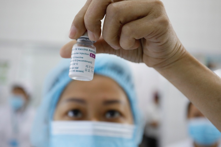 A health worker in HCMC Hospital for Tropical Diseases holds a dose of AstraZeneca vaccine in March, 2021. Photo by VnExpress/ Huu Khoa.