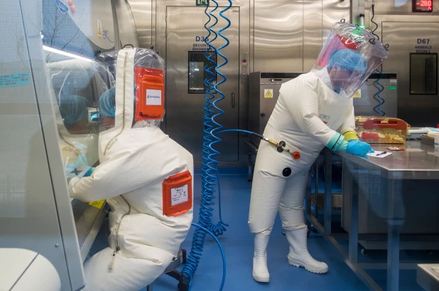 Workers are seen next to a cage with mice inside a lab at the Wuhan Institute of Virology.AFP via Getty Images