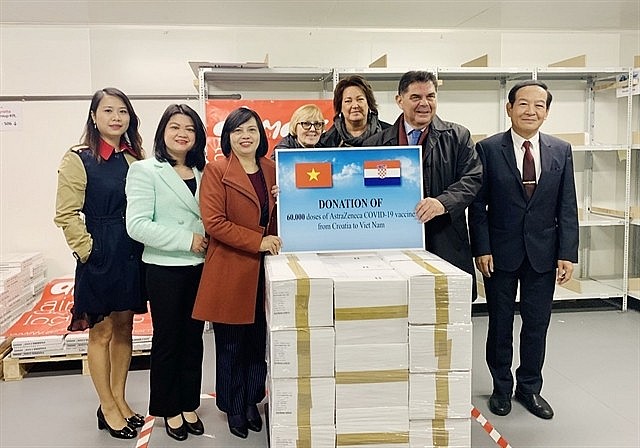 Croatian Ambassador to Hungary Mladen Andrlić (second from right) presents donation of COVID-19 vaccines to Vietnamese Ambassador to Hungary Nguyễn Thị Bích Thảo (third from left). — VNA/VNS Photo 