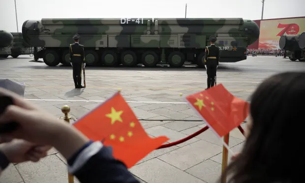 Chinese military vehicles carrying DF-41 ballistic missiles drive past flag-waving spectators during a parade in Beijing. Photograph: AP