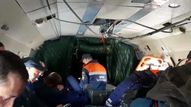 A group of rescuers involved in the search for the An-26 plane on board a Mi-8 helicopter, in Kamchatka [Emercom Of Russia Press Service Handout via EPA-EFE]