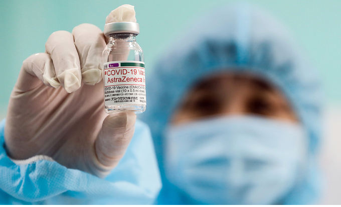 A medical worker holds up a vial containing the AstraZeneca Covid-19 vaccine in HCMC. Photo by VnExpress/Huu Khoa.