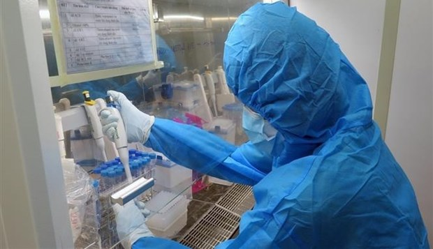 A medical worker performs COVID-19 testing inside a mobile container lab in Vietnam. (Photo: VNA)