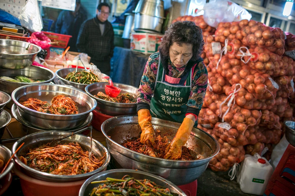 Making kimchi at a Seoul market.Credit: Jean Chung for The New York Times