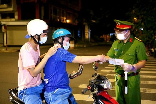 Police in HCM City check people on the streets after 6pm on July 26, the day the night-time restriction took effect, and fine them for flouting night-time lockdown rules. VNA/VNS.Photo Thành Chung