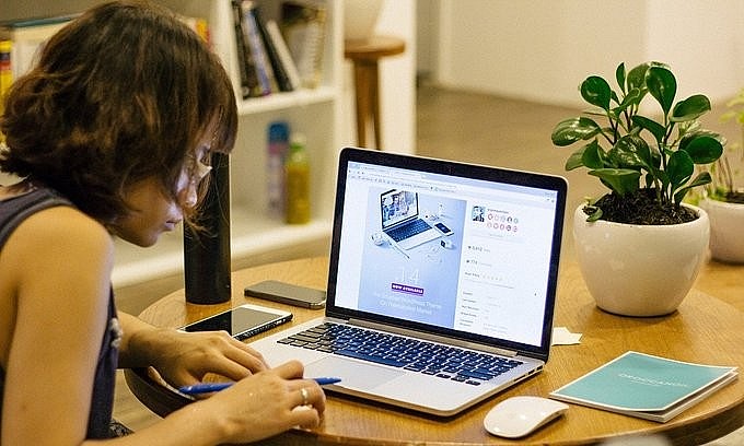 A woman works on a laptop. Photo by Pixabay.