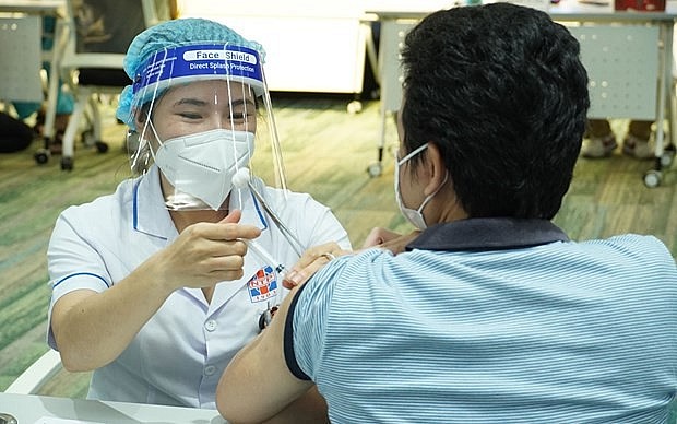 A medical worker gives COVID-19 vaccine shot to a man in HCM City. (Photo: VNA)