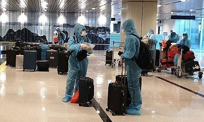 Passengers wait to get their luggage after arriving at Van Don Airport in Quang Ninh Province on a flight from Japan, September 4, 2021. Photo by VnExpress