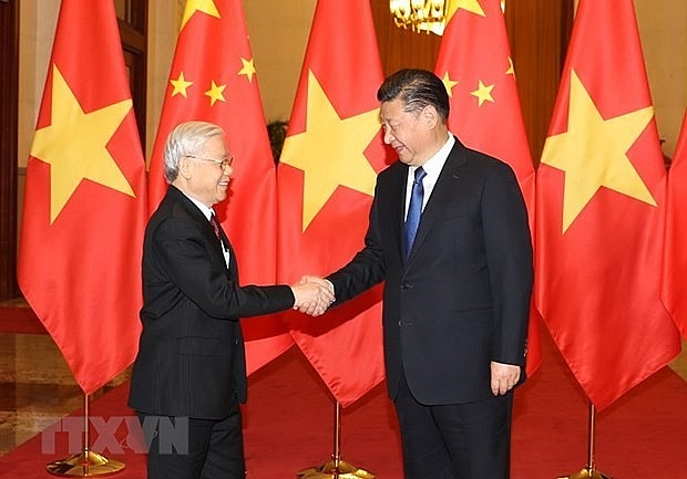 General Secretary of the Communist Party of China Central Committee and President of China Xi Jinping (R) welcomes General Secretary of the Communist Party of Vietnam Central Committee Nguyen Phu Trong during the latter's visit to China in 2017 (Photo: VNA)