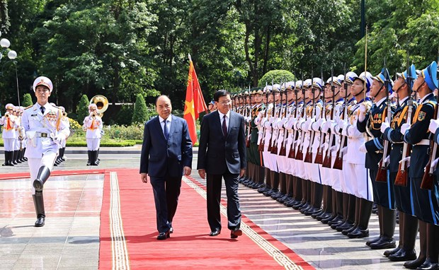 Vietnamese President Nguyen Xuan Phuc (L) and General Secretary of the Lao People’s Revolutionary Party Central Committee and President of Laos Thongloun Sisoulith inspect the guard of honour at the welcome ceremony in Hanoi on June 28 (Photo: VNA)