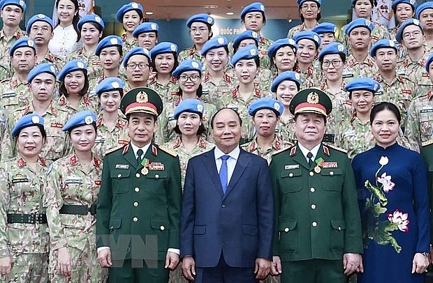 State President Nguyen Xuan Phuc, Minister of National Defense, General Phan Van Giang, Head of the Central Propaganda Department Nguyen Trong Nghia took a photo with the peacekeeping force of Vietnam, which has successfully completed the task. (Photo: Thong Nhat/VNA)