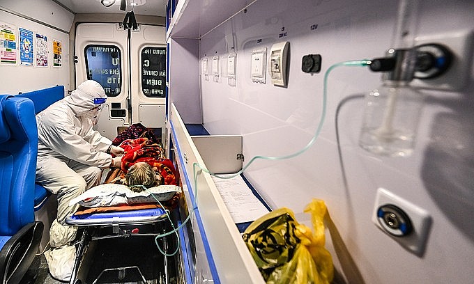A doctor takes care of a Covid-19 patient as she is transferred to a hospital for emergency aid in Hanoi, December 23, 2021. Photo by VnExpress