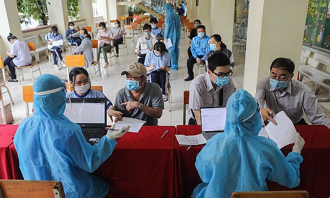 Students wait for Covid-19 vaccination as their parents are consulted at the Luong The Vinh High School in HCMC's District 1, October 27, 2021. Photo: VnExpress