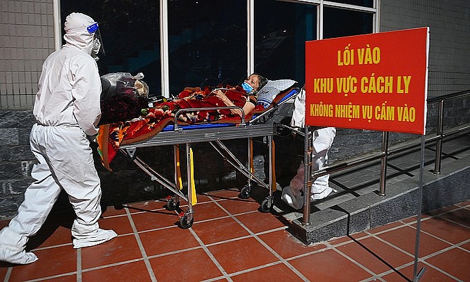 A doctor sends a Covid-19 patient into a hospital in Hanoi, December 23, 2021. Photo: VnExpress