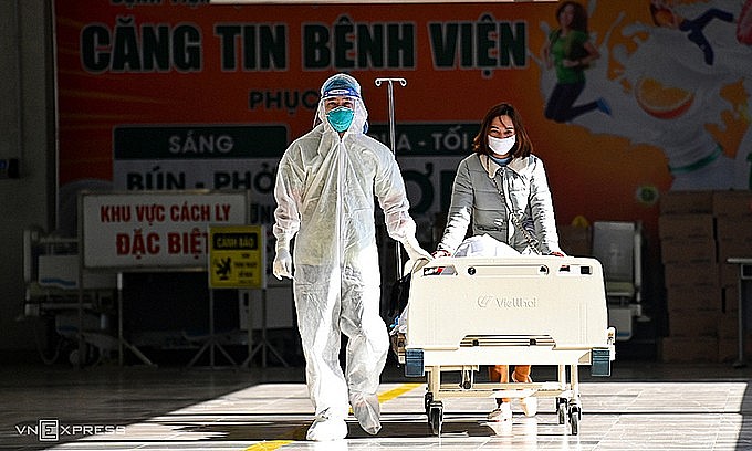 Medical staff take a critically ill Covid patient into the ICU at National Hospital of Tropical Diseases in Hanoi, December 2021. Photo by VnExpress/Giang Huy