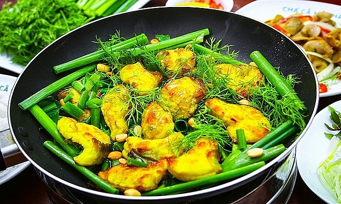 Cha ca, fried catfish dish, is served in a pan at a restaurant on La Vong Street in Hanoi. Photo: VnExpress