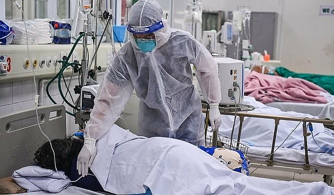 A doctor takes care of a Covid-19 patient at the National Hospital for Tropical Disease in Hanoi in 2021. Photo: VnExpress