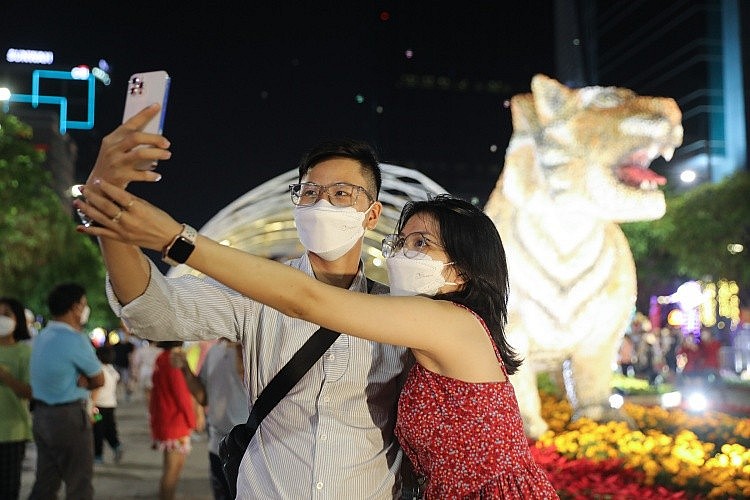 A couple takes pictures at Nguyen Hue flower street on Jan 29, 2021. Photo: VnExpress