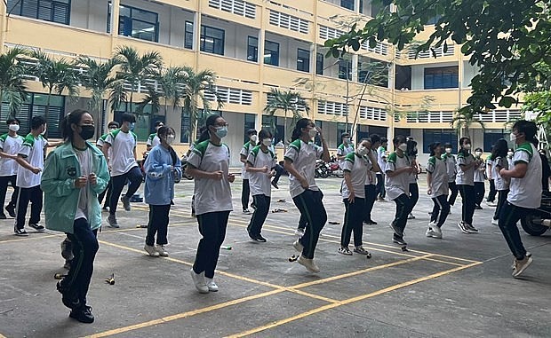 Students with face masks on during a physical education lesson in HCM City (Photo: VNA)