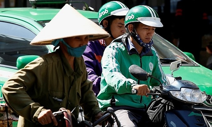 A GrabBike driver at work in Hanoi. Photo: Reuters