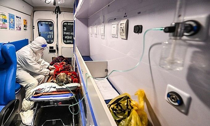 A doctor attends to a Covid-19 patient on an ambulance in Hanoi. Photo: VnExpress