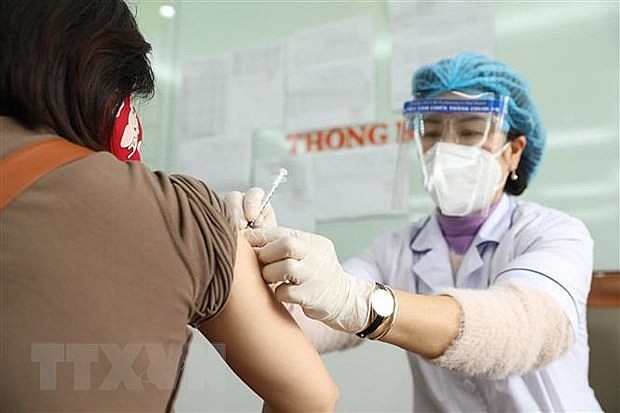 A health workers gives a COVID-19 vaccine shot to a resident of Le Dai Hanh ward in Hanoi's Hai Ba Trung district. Photo: VNA
