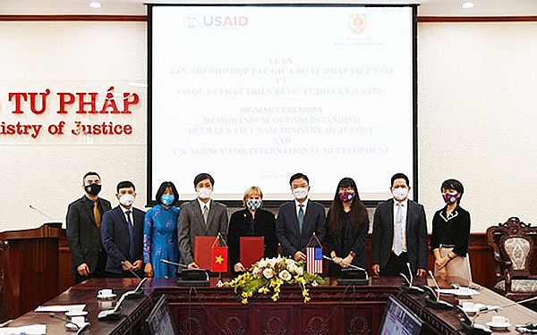 USAID Vietnam’s Mission Director Ann Marie Yastishock (5th from right) and Deputy Minister of Justice Nguyen Khanh Ngoc (4th from right) sign the MoU, Hanoi, March 8, 2022. Photo: VNN