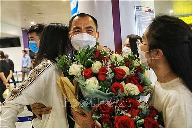 A repatriated Vietnamese man is welcomed by his relatives at Noi Bai International Airport in Hanoi on March 19. Photo: VNA