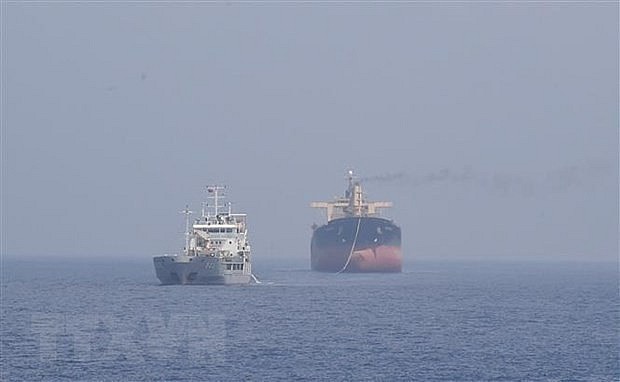 Panamanian vessel Pacific 07 (right) is being tugged to a location near Song Tu Tay Island for repair. Photo: VNA
