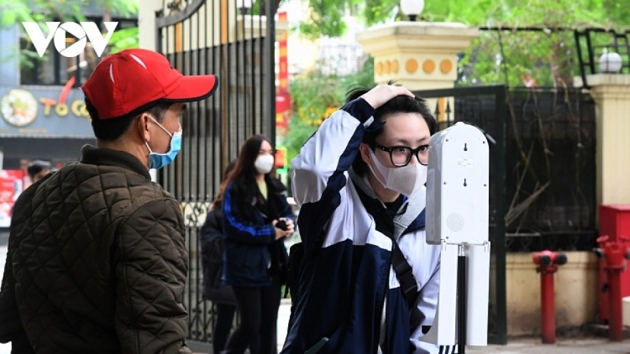 Students are required to use hand sanitizer dispenser before entering the class. Photo: VOV