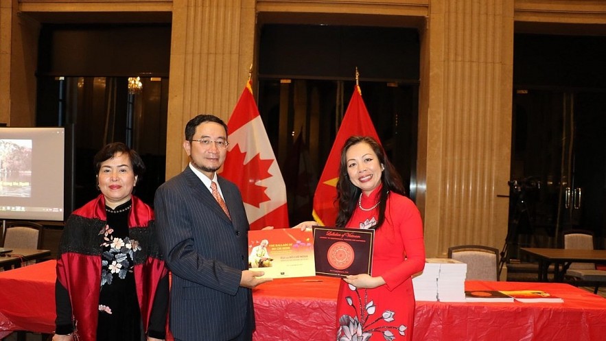 Professor Julie Nguyen (far right) presents Vietnamese Ambassador to Canada Pham Cao Phong and his wife two works of the professor. Photo: VNA