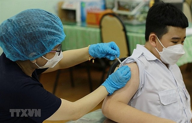 A sixth-grade student of the Hồng Bàng Secondary School in HCM City’s District 5 gets vaccinated against COVID-19 on April 16.  Photo: VNS