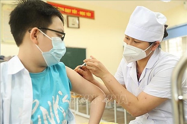 Health worker gives a COVID-19 vaccine jab for a child. Photo: VNA