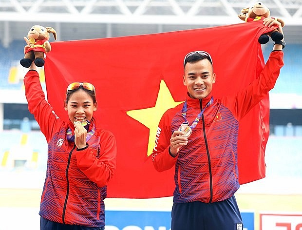Nguyen Thi Thanh Phuc, gold medallist in the women's 20km walk and her brother Nguyen Thanh Ngung, bronze medallist in the men's 20km walk, pose for a photo. Photo: VNA