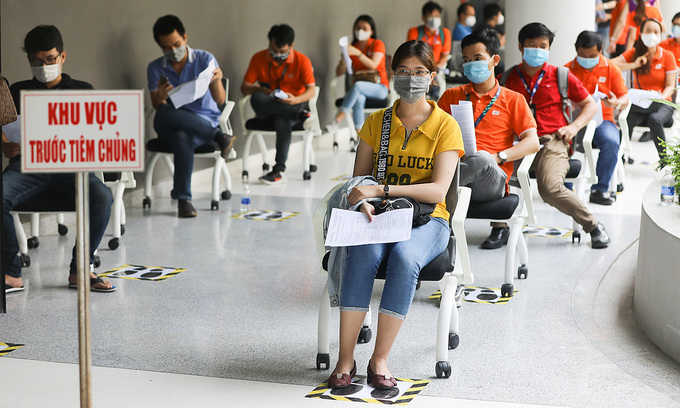 People wait in line for their turn to get the Covid-19 vaccine in HCMC, June 19, 2021. Photo: VnExpress
