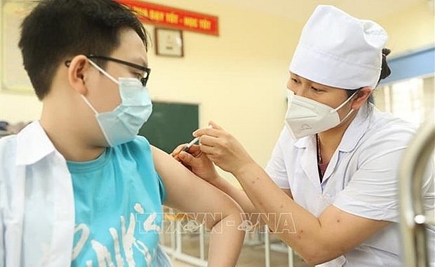 A boy gets vaccinated against Covid-19. Photo: VNA