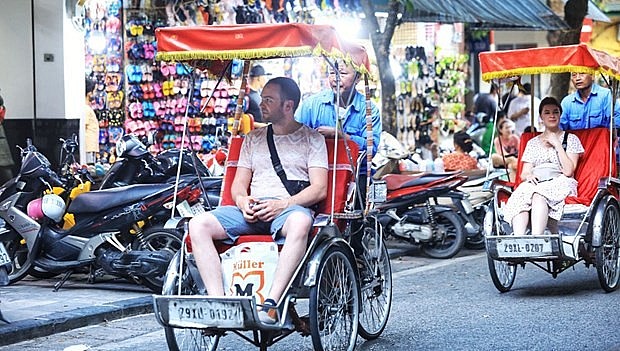 Foreign tourists enjoy a cyclo tour of Hanoi. Photo: VNA